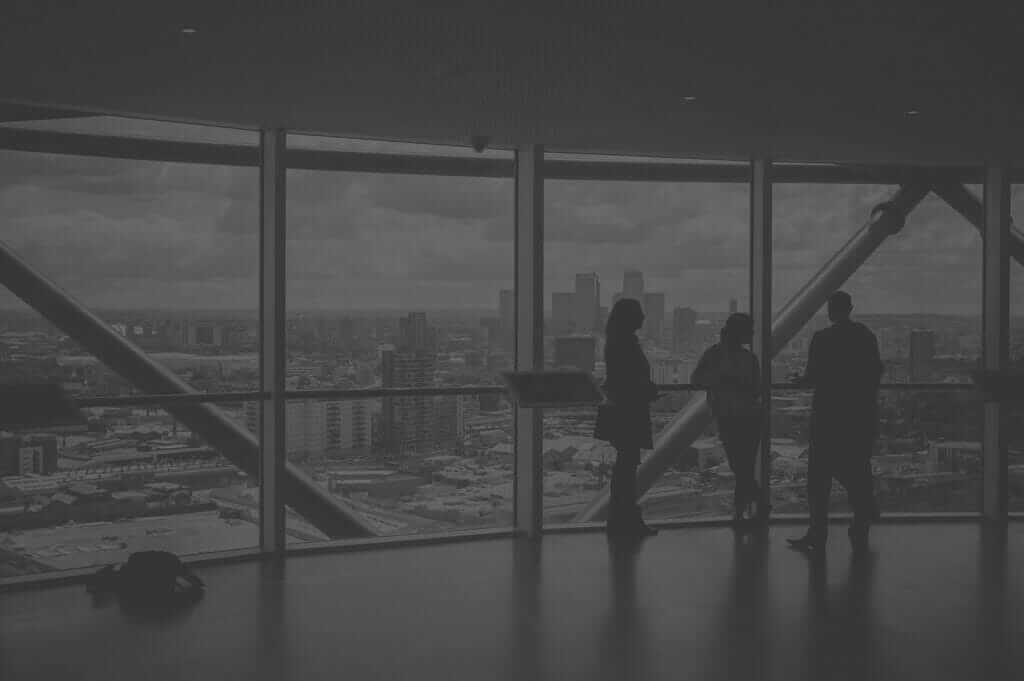 Project Designers Standing Inside Tall Building Looking Out Over The City