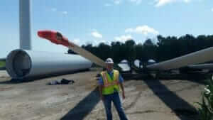 MTC employee in front of wind farm turbine