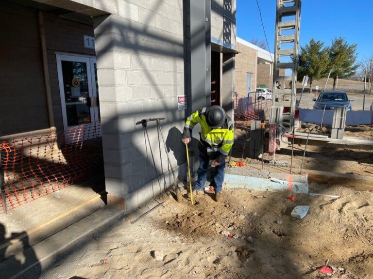 MTC construction worker measuring soil at worksite