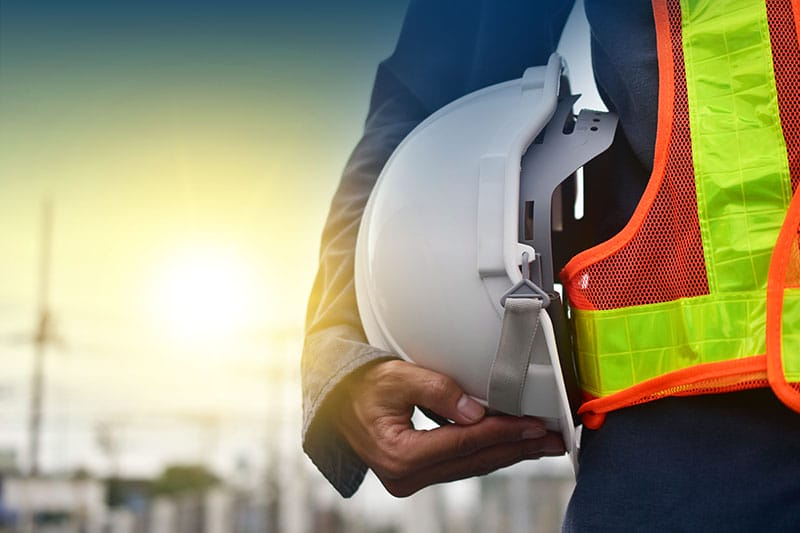 Technician holding a hard hat to show safety preparation