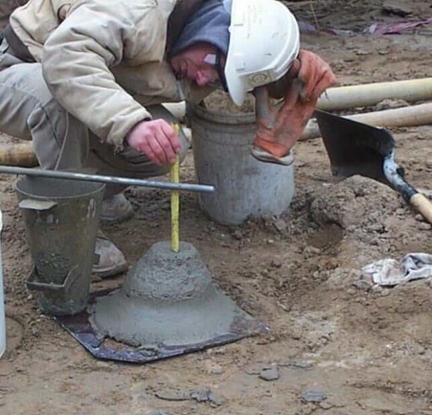 Construction materials technician performing slump testing on a concrete sample