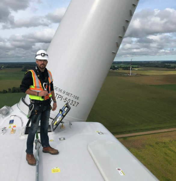 Worker standing on wind turbine