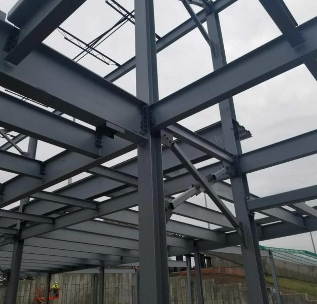 structural steel inspection takes place underneath large steel beams connected in a floor grid