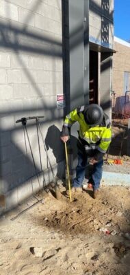MTC construction worker measuring soil at worksite